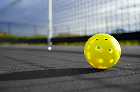 Close up of a pickleball on pickleball court.